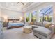 Serene main bedroom boasting tray ceilings, large windows, and a comfortable seating area at 16677 Vibrato Ln, Land O Lakes, FL 34638