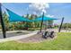 A neighborhood playground features swings, a play structure, sunshades, and seating for Gathering fun in the sun at 16677 Vibrato Ln, Land O Lakes, FL 34638