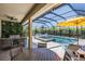 Inviting screened-in pool area with a spa, comfortable seating, and a lush green wall for added privacy at 16677 Vibrato Ln, Land O Lakes, FL 34638