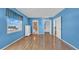 Bright blue bedroom features wood floors, large windows, and en suite bath and closet access at 17400 Gulf Blvd # J7, Redington Shores, FL 33708
