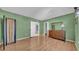 Bedroom featuring wood floors, green walls, and an en-suite bathroom at 17400 Gulf Blvd # J7, Redington Shores, FL 33708