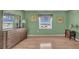 Bright bedroom features wood floors, large windows with views, and charming nautical decor at 17400 Gulf Blvd # J7, Redington Shores, FL 33708