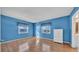 Cozy bedroom with blue walls, wood floor, two windows, and bright natural light at 17400 Gulf Blvd # J7, Redington Shores, FL 33708