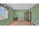 Bright bedroom features wood floors, an accent wall, and large window with coastal views at 17400 Gulf Blvd # J7, Redington Shores, FL 33708