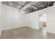 Bedroom with exposed ceiling and concrete floors, offering a view into the adjacent bathroom at 175 2Nd S St # 907, St Petersburg, FL 33701