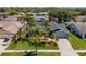 Aerial view of home featuring well-maintained lawn, mature landscaping, and a paved driveway at 1805 Stable Trl, Palm Harbor, FL 34685