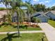 Aerial view of home featuring well-maintained lawn, mature landscaping, and a paved driveway at 1805 Stable Trl, Palm Harbor, FL 34685