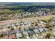 An aerial perspective of a residential area near a highway and wooded areas, showing homes with pools at 1805 Stable Trl, Palm Harbor, FL 34685