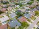 An aerial view features homes with pools, lush landscaping, and neat lawns in an attractive residential community at 1805 Stable Trl, Palm Harbor, FL 34685