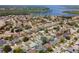 An aerial view highlights homes with trees and a nearby lake access, perfect for outdoors enthusiasts at 1805 Stable Trl, Palm Harbor, FL 34685
