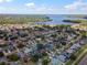 An aerial view displays homes with lush trees and nearby lake access, perfect for peaceful living at 1805 Stable Trl, Palm Harbor, FL 34685