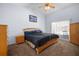 Cozy bedroom features a comfortable bed, closet, and a sliding glass door to the pool area at 1805 Stable Trl, Palm Harbor, FL 34685