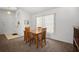 A dining room features light walls, neutral carpet and a wooden table with four matching chairs at 1805 Stable Trl, Palm Harbor, FL 34685