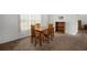 A dining room features light-colored walls, neutral carpet and a wooden table with matching chairs at 1805 Stable Trl, Palm Harbor, FL 34685