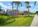 Well-manicured lawn features mature palm trees, lush landscaping, and a neatly kept lawn at 1805 Stable Trl, Palm Harbor, FL 34685