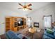 Cozy living room with a fireplace, ceiling fan, and entertainment center at 1805 Stable Trl, Palm Harbor, FL 34685