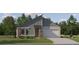 Modern single-Gathering home with stone accents, gray siding, an attached garage, and manicured front lawn at 18452 Serene Lake Loop, Lutz, FL 33548