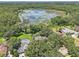 An elevated view shows properties with pools, lush greenery, and lake at 1927 Curry Rd, Lutz, FL 33549