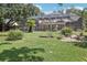 Lush backyard showcasing a screened enclosure, expansive lawn, and mature landscaping at 1927 Curry Rd, Lutz, FL 33549