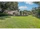Expansive backyard with mature landscaping, a play area, and well-maintained lawn at 1927 Curry Rd, Lutz, FL 33549