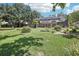 Spacious backyard featuring a screened enclosure, lush lawn, and mature trees at 1927 Curry Rd, Lutz, FL 33549
