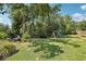 Lush backyard featuring a swing set, mature trees, and a well-maintained lawn at 1927 Curry Rd, Lutz, FL 33549