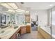 Bright bathroom boasts double sinks, a soaking tub, and doorway to an adjacent bedroom at 1927 Curry Rd, Lutz, FL 33549