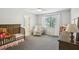 Cozy bedroom with a rocking chair, crib, and a window at 1927 Curry Rd, Lutz, FL 33549