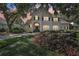 Elegant two-story home with a stone facade, arched entryway, and professionally landscaped yard at 1927 Curry Rd, Lutz, FL 33549