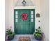 Inviting front door with a floral wreath, potted plants, American flags, and a 'Hello Spring' doormat at 1927 Curry Rd, Lutz, FL 33549