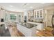 Bright kitchen with white cabinets, granite countertops, and stainless steel appliances, with an island and an adjacent dining area at 1927 Curry Rd, Lutz, FL 33549