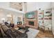 Open living room with a brick fireplace, built-in shelves, and a staircase in a bright, spacious interior at 1927 Curry Rd, Lutz, FL 33549