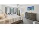 Bright main bedroom features a ceiling fan, carpet, and three rear-facing windows at 1927 Curry Rd, Lutz, FL 33549