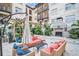 Outdoor patio with plush coral seating, decorative lighting, and a stone fireplace providing a relaxing and inviting atmosphere at 200 4Th S Ave # 303, St Petersburg, FL 33701
