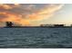 Scenic pier view at sunset, featuring modern architecture and palm trees against a colorful sky on a calm ocean at 200 4Th S Ave # 303, St Petersburg, FL 33701