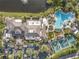 An aerial view of a community clubhouse with a resort-style pool, tennis courts, and lush landscaping at 2309 New Orchard Ct, Sun City Center, FL 33573