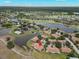 Aerial view of the home surrounded by ponds and mature trees in a well-established neighborhood at 2309 New Orchard Ct, Sun City Center, FL 33573
