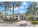 An inviting community clubhouse entrance framed by palm trees and colorful landscaping at 2309 New Orchard Ct, Sun City Center, FL 33573