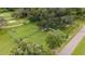 Aerial view of a fenced dog park with agility equipment and benches surrounded by mature trees at 2309 New Orchard Ct, Sun City Center, FL 33573