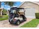 A golf cart parked in a driveway with clubs, showcasing the convenience for golf enthusiasts at 2309 New Orchard Ct, Sun City Center, FL 33573