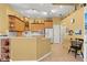 Bright kitchen featuring tile flooring, light wood cabinets, granite countertops, and modern appliances at 2309 New Orchard Ct, Sun City Center, FL 33573