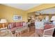 Comfortable living room with wood floors, wicker furniture, and view to kitchen and second living area at 2309 New Orchard Ct, Sun City Center, FL 33573
