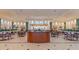 Bright lobby space with tile floors, potted plants, multiple tables and chairs, and a reception desk at 2309 New Orchard Ct, Sun City Center, FL 33573