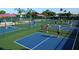 Aerial view of community pickleball courts with players engaged in games on the colorfully painted surface at 2309 New Orchard Ct, Sun City Center, FL 33573