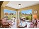Bright sun room with walls of windows overlooking a grassy field and patio table with chairs at 2309 New Orchard Ct, Sun City Center, FL 33573