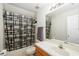 Bright bathroom featuring a combination tub and shower, a large mirror, and a neutral palette at 2513 Regal River Rd, Valrico, FL 33596