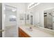 Bathroom showcasing a well-lit vanity area with a large mirror, complemented by a view into an adjacent bedroom at 2513 Regal River Rd, Valrico, FL 33596