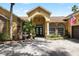 Close-up view of the home's entrance featuring a fountain, brick accents, and manicured landscaping at 2513 Regal River Rd, Valrico, FL 33596