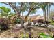 Charming front yard with mature trees, lush landscaping, and a decorative fountain at 2513 Regal River Rd, Valrico, FL 33596