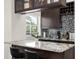 Modern kitchen features dark wood cabinets, granite countertops, stainless appliances, and a mosaic backsplash at 2513 Regal River Rd, Valrico, FL 33596